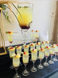 a table topped with lots of glasses filled with different types of drinks and garnishes