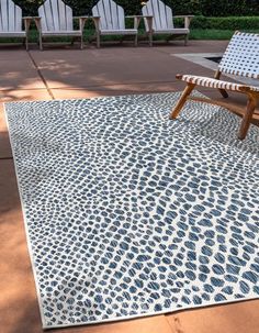 a blue and white area rug sitting on top of a wooden floor next to lawn chairs