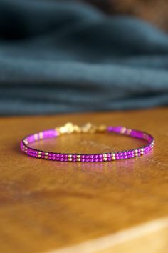 a purple bracelet sitting on top of a wooden table