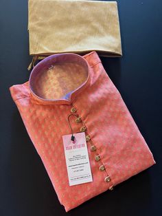 Premium quality Banarasi Silk Men's Kurta Pajama Set for Men with Woven Buttis all over the front and back of the Kurta with fancy buttons on the neckline. The Kurta does not have a lining. Item : Men's Kurta PajamaReady to Wear : YesKurta Color : Peachy PinkPajama Color : Gold Pocket : YesFabric : Banarasi Silk (Non Pure Silk)Work : Fancy buttons, Woven Zari workPattern : DesignerLining : No Shalwar Kameez Pakistani, Sherwani For Men Wedding, Red Kurta, Men's Kurta, Kurta Men, Mens Kurta Designs, Kurta Pyjama, Kurta Design, Wedding Dress Men