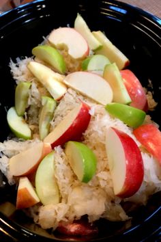 an apple salad in a black bowl on a table