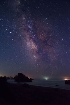 the night sky is filled with stars and bright lights, as well as some rocks