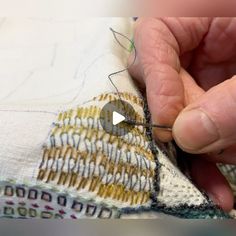 a person is stitching something on a piece of fabric