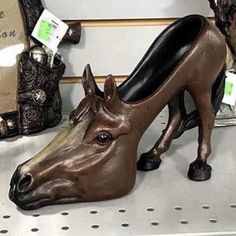 there is a horse head statue on the shelf next to other decorative items and bags