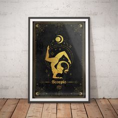 the zodiac sign in gold and black on a wooden floor