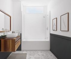 a bathroom with a sink, mirror and bathtub next to a wall mounted shower