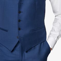 Mid blue waistcoat with a slim fit, featuring a V-neck collar, jetted pockets, single-breasted 5-button closure, and a rear cinch for an adjustable fit. Blue Three-piece Suit With Notch Lapel And Pockets, Blue Three-piece Suit With Notch Lapel, Blue Three-piece Suit With Single Button, Classic Blue Three-piece Suit With Pockets, Fitted Business Vest With Pockets, Classic Blue Three-piece Suit, Classic Blue Three-piece Suit With Single Button, Blue Three-piece Suit With Welt Pockets For Business Casual, Blue Slim Fit Three-piece Suit With Single Button