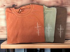 Love these delicate, simply stated cross tees!!   This is a premium tee from Comfort Colors. Photo shows the shirt color in Yam, Sandstone and Espresso. All colors are available.  See colors and size chart.  All shirts will be stitched with ivory for the cross and flowers.  - Comfort Colors Unisex sizing - Embroidered design Please message me with any questions! cancellations will not be refunded if your shirt has been ordered. I do not keep stock on hand. Cross Shirt Designs, Cross Tshirt Designs, Everyday Cotton T-shirt With Embroidered Graphics, Christian Wear, Unisex Christian Tee Shirts, Christian Cross Tshirt, Embroidered Tee Shirt, Christian Embroidery, Christian Shirts Designs