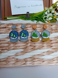 four christmas ornaments sitting on top of a wicker basket