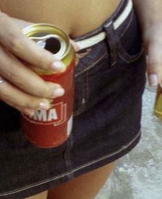 a woman is holding a can of soda