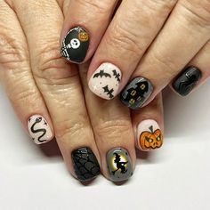 a woman's hands with halloween nail art on them