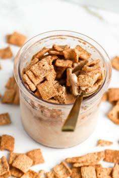 a glass jar filled with cereal flakes and a spoon