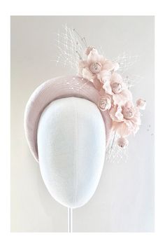 a white hat with pink flowers on it and a head piece in the shape of a flower