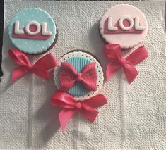 two decorated cookies with bows on top of each one are sitting on a white napkin