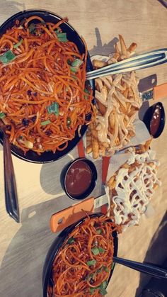 two pans filled with food sitting on top of a table next to utensils