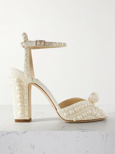 a white high heeled shoe with pearls