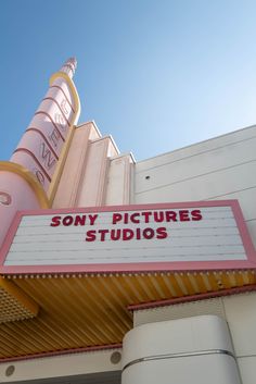 there is a sign that says sony pictures studios on the side of a building in front of a blue sky