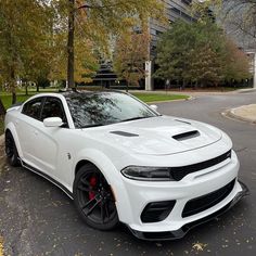 a white dodge charger parked in front of a building