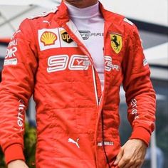 a man in a red racing suit is holding his hand on his hip and looking to the side