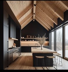 a kitchen with wooden ceilings and black cabinets