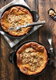 two pumpkin pie dutch bakes with cinnamon streusel in them on top of a wooden table