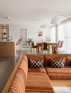 a living room filled with furniture next to a kitchen