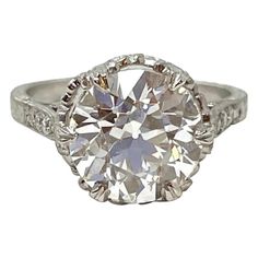 an antique style diamond ring with diamonds on the shoulders and sides, set in white gold