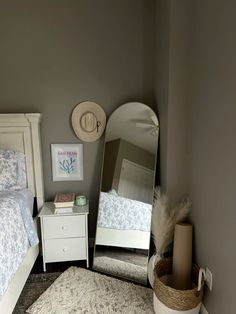 a white bed sitting next to a mirror on top of a dresser