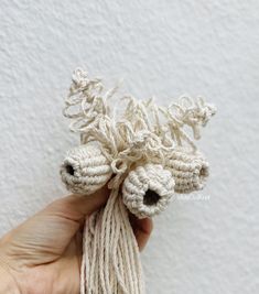 someone is holding some crocheted items in their hand and they are all white