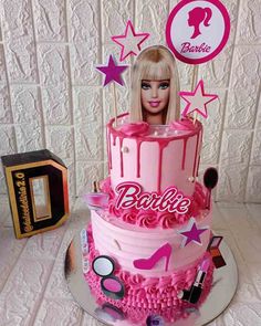 a barbie doll cake with pink icing and decorations