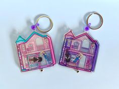 two key chains that are shaped to look like houses with windows and doors on them