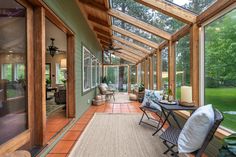 a covered porch with chairs and tables on it