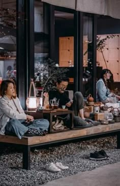 people sitting on a bench in front of a store