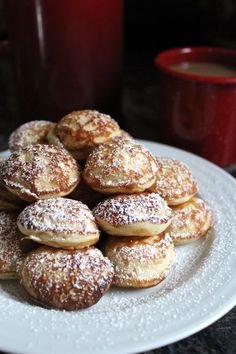 a white plate topped with powdered sugar covered donuts