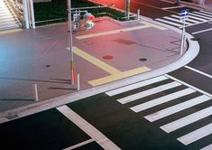 an overhead view of a city street at night with traffic lights and pedestrian crosswalks