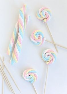 colorful lollipops and candy sticks on a white surface