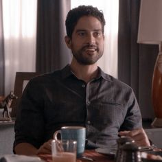 a man sitting at a table with two coffee mugs