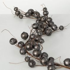 a bunch of metal balls sitting on top of a branch