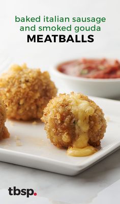 three fried food items on a white plate next to a small bowl of dip and sauce