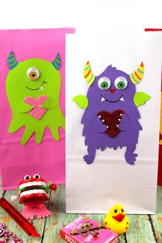 two paper bags decorated with monsters and hearts