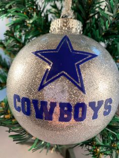 a christmas ornament with the word cowboys on it and a blue star in the center