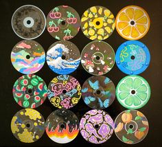 a bunch of different colored discs sitting on top of a black table next to each other