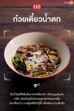 a bowl filled with meat and vegetables on top of a wooden table next to an advertisement for