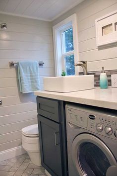 a bathroom with a washer and dryer on the counter in front of it