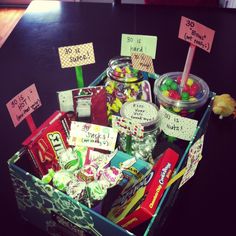 a box filled with candy and candies on top of a black table next to a teddy bear