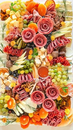 a platter filled with lots of different types of meats and cheeses on top of each other