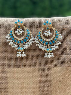 **Stunning Ethnic Blue and White Jhumka Earrings** Elevate your style with these exquisite ethnic jhumka earrings, beautifully handcrafted to add a touch of elegance and tradition to your wardrobe. These statement earrings feature a captivating combination of blue stones and white pearls, meticulously arranged to create a mesmerizing design that is perfect for any occasion. **Features - **Design Traditional Chandbali style with intricate detailing. - **Materials High-quality blue stones, white p Traditional Blue Chandbali Chandelier Earrings, Bohemian Chandbali Jhumkas For Eid, Traditional Blue Dangle Chandbalis, Blue Chandbali Chandelier Earrings, Traditional Blue Kundan Chandelier Earrings, Blue Chandbali Chandelier Earrings For Festivals, Blue Meenakari Chandbali Chandelier Earrings, Traditional Blue Chandbali Bridal Earrings, Blue Chandbali Bridal Earrings For Diwali