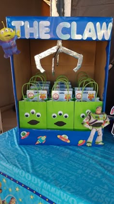 the claw display is set up on top of a blue tablecloth with toy characters