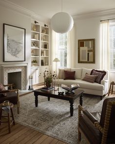 a living room filled with furniture and a fire place under a lamp hanging from the ceiling