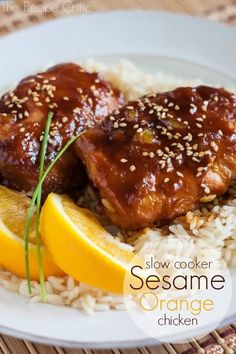 slow cooker sesame orange chicken on rice with lemon wedges and garnish